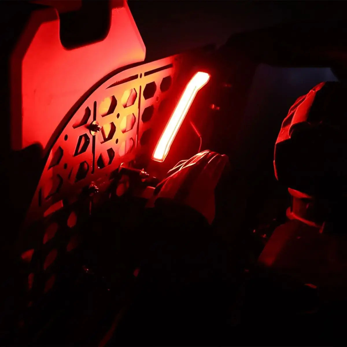 Close-up of a red light on a mechanical component in a dark setting