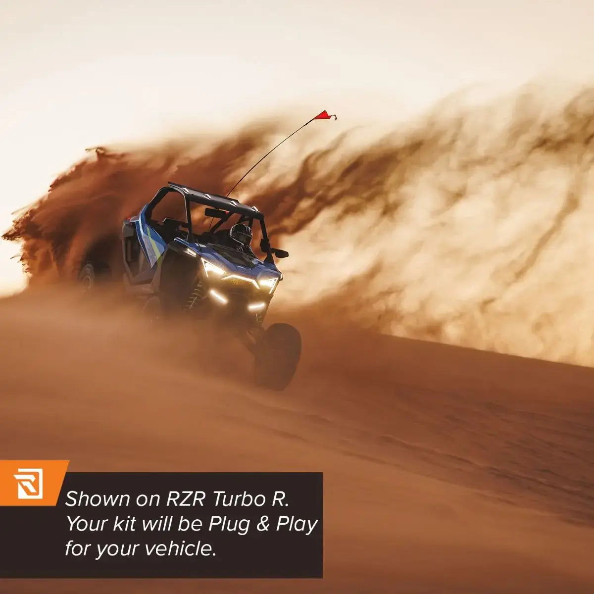 Dune buggy kicking up sand in a desert with promotional text for RZR Turbo R.
