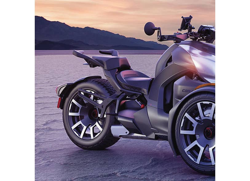 Can-Am Ryker saddlebag rack mounted on rear wheel of silver three-wheeler at sunset
