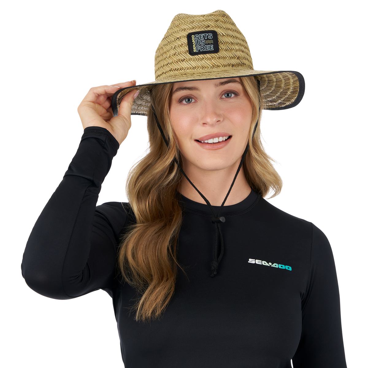 Woman wearing a Sea-Doo Sets Us Free straw hat, featuring a wide brim and adjustable chin strap for sunny outdoor activities.