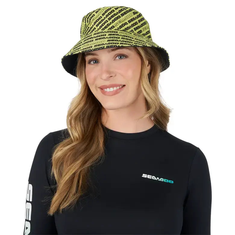 Woman wearing a Sea-Doo reversible bucket hat featuring a bright design, with a Sea-Doo logo on her shirt.