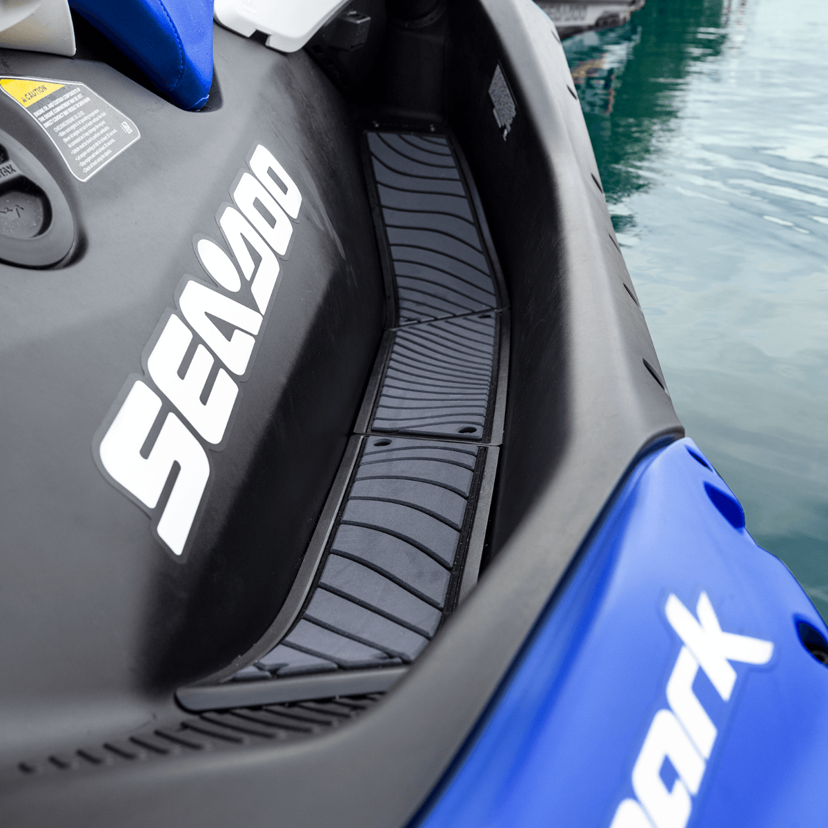 A blue and black jet ski parked next to a body of water