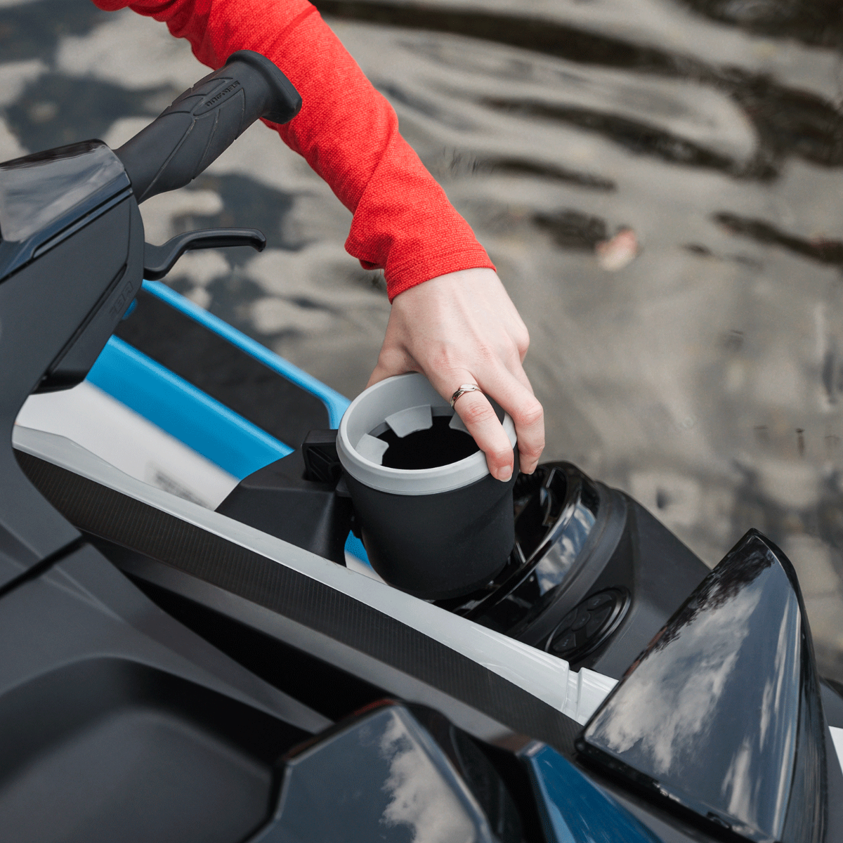 Rider reaching for a drink in the Sea-Doo LinQ cup holder on a watercraft