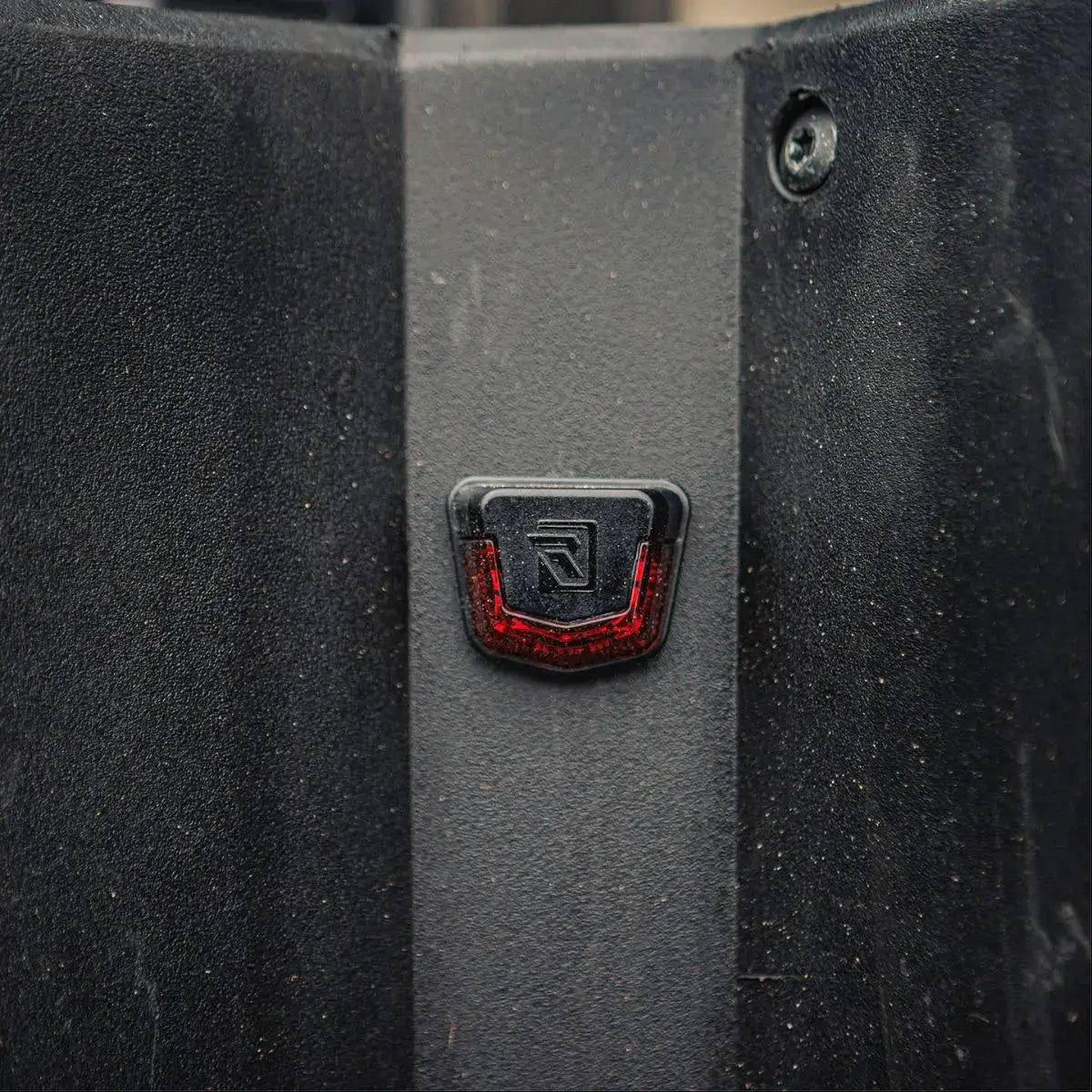 Close-up of a black textured surface with a red and black logo in the center.