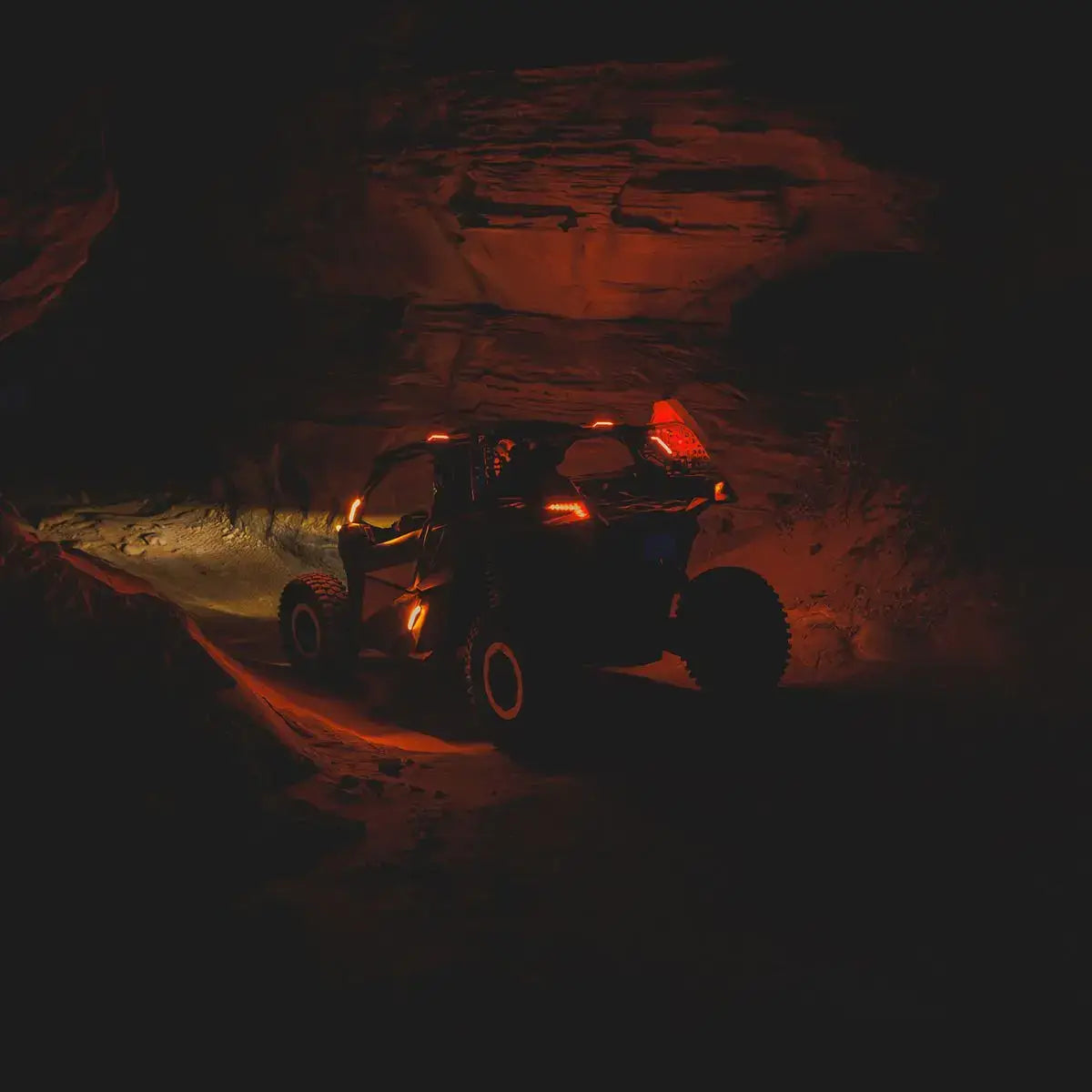 Can-Am UTV inside a dark cave with red lighting