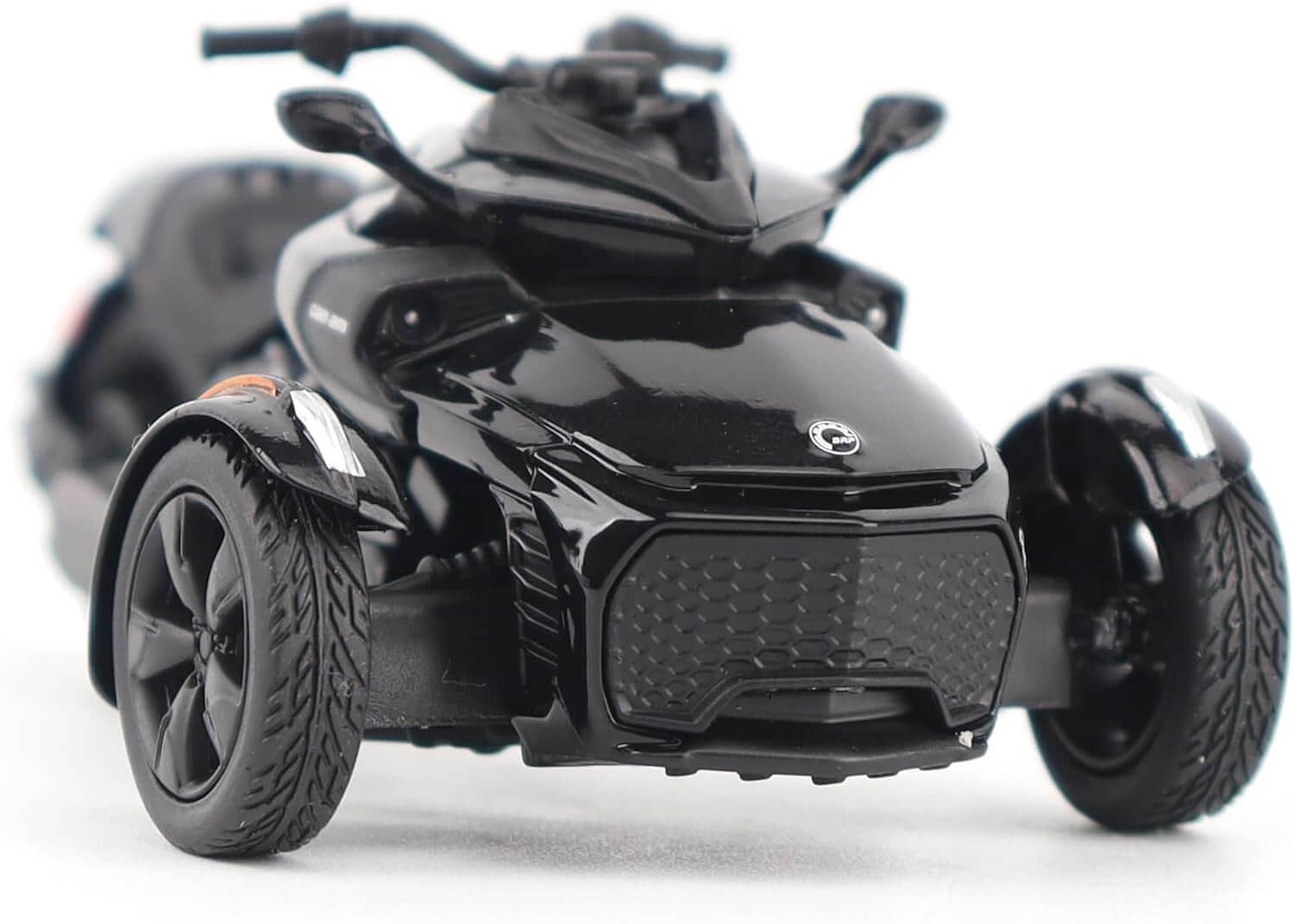 Black three-wheeled toy vehicle on a white background