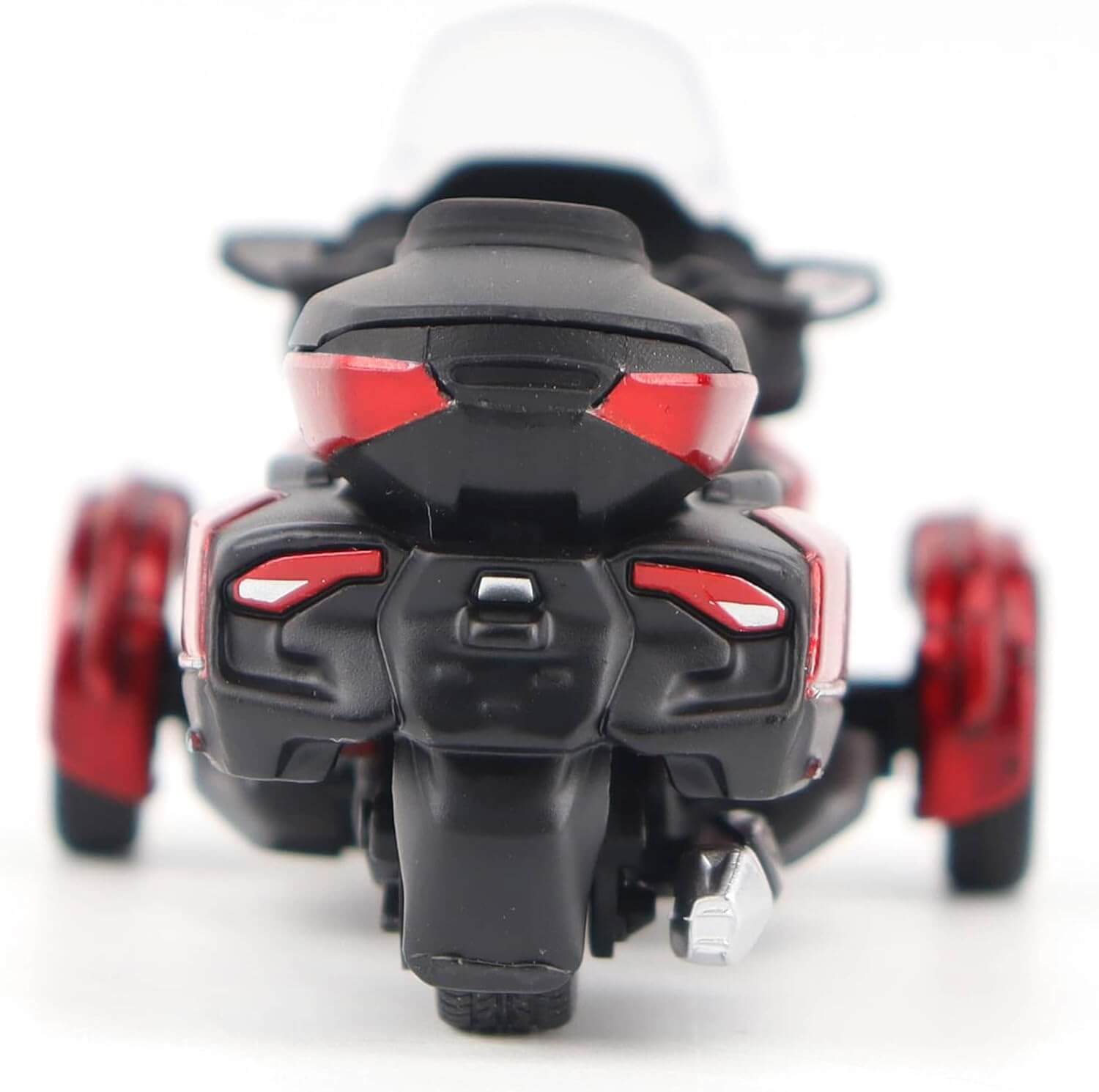 Close-up of a black and red three-wheeled toy vehicle on a white background