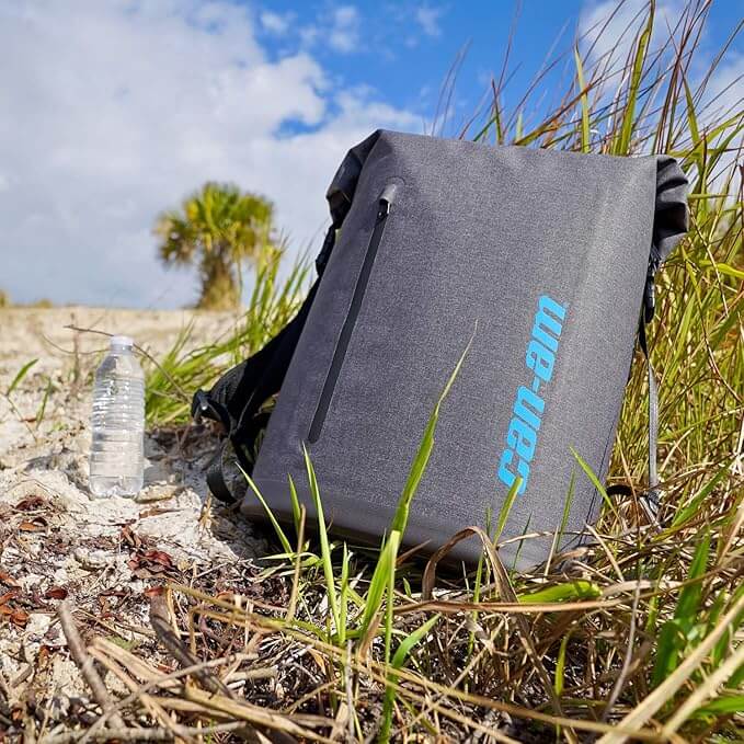 Gray backpack with 'can-am' branding on a grassy outdoor setting