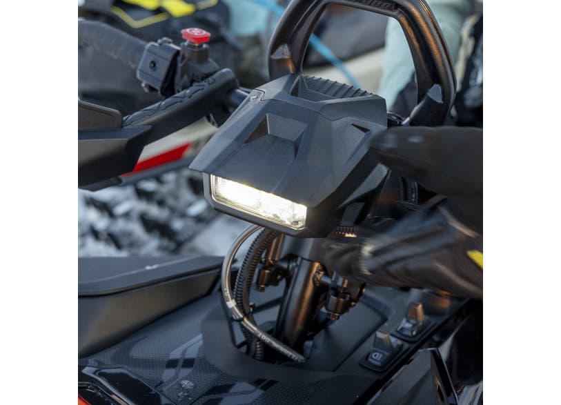 Ski-Doo auxiliary LED light mounted on snowmobile handlebar, illuminated close-up view, 860202429