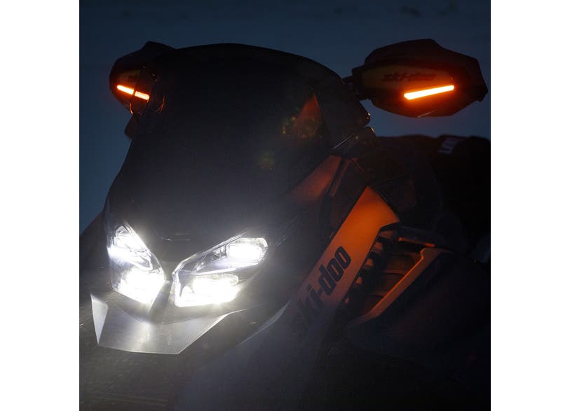 Ski-Doo REV Gen5 Gen4 snowmobile with LED signal lights glowing on handguards at night, 860202619