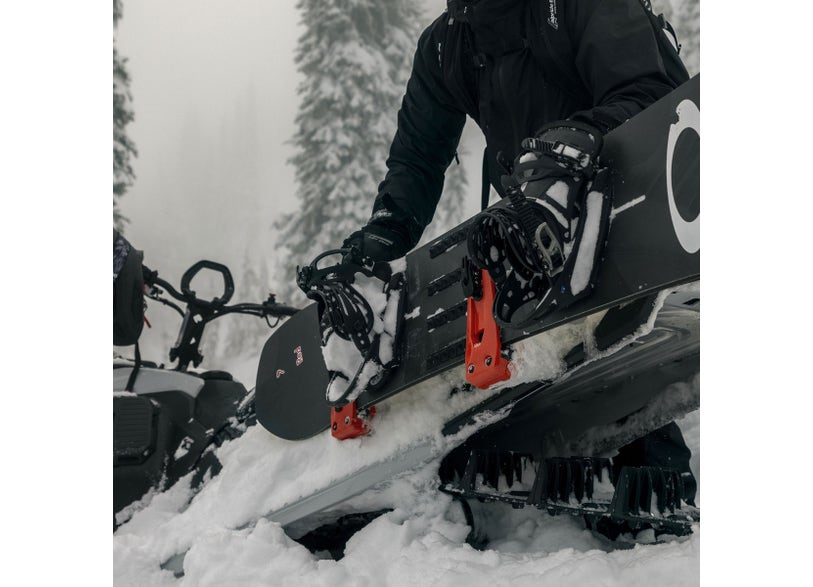 Rider mounting a snowboard on the Ski-Doo LinQ Snowboard / Ski Rack 860202741