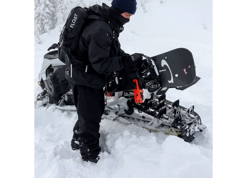 Rider loading a snowboard on the Ski-Doo LinQ Snowboard / Ski Rack 860202741
