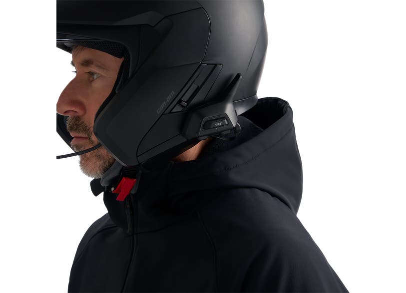 Rider wearing Can-Am helmet with BRP Vibe Universal Comm System mounted, side view