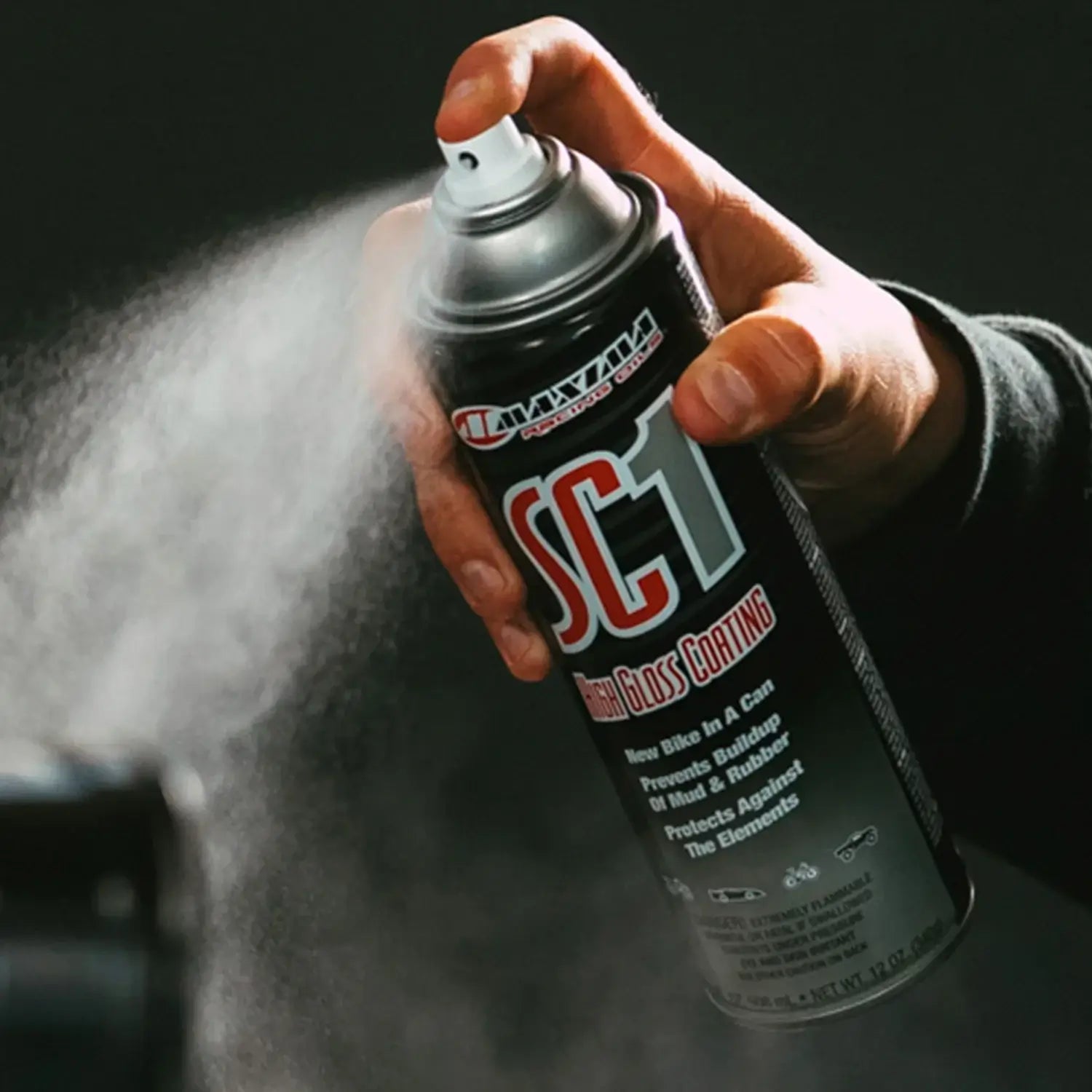 Hand holding a spray can labeled 'SC1' with a dark background