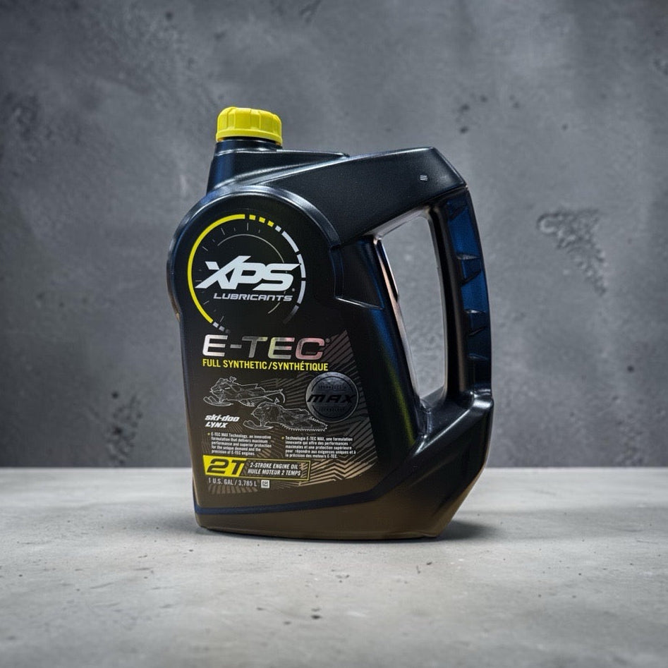 A black plastic bottle of XPS Lubricants E-TEC Full Synthetic Motor Oil with a bright yellow cap, set against a textured gray concrete background.