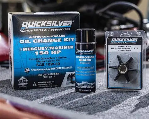 Quicksilver marine parts and accessories including an oil change kit and replacement fan on a blurred background.