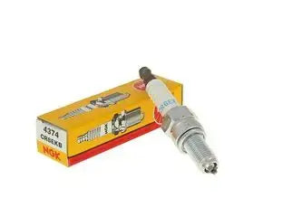 Spark plug and its packaging on a white background