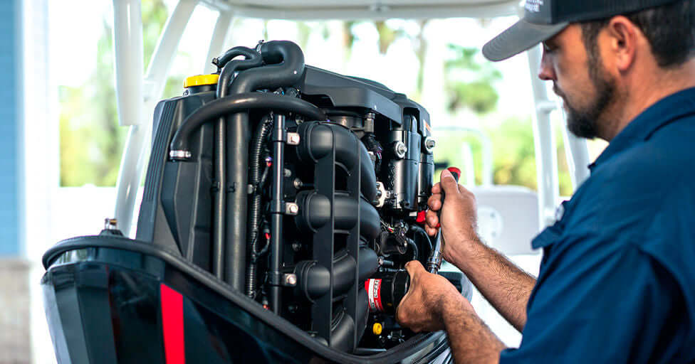 Person working on a boat engine with a blurred background.