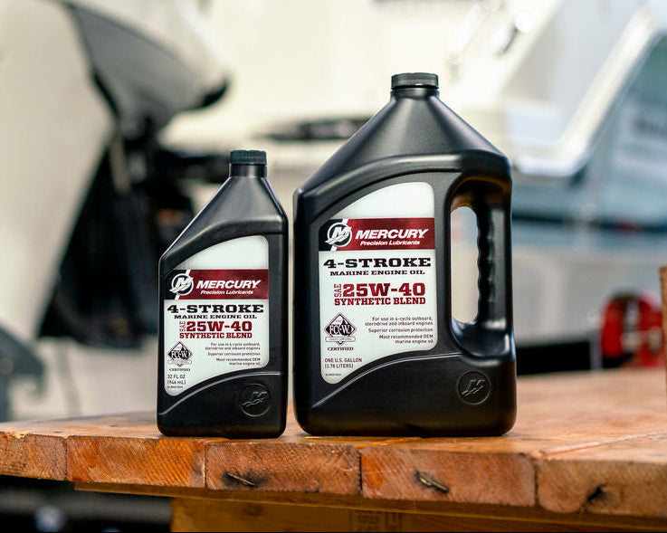 Two bottles of Mercury 4-stroke outboard motor oil on a wooden table with a blurred background of white outboard motors.