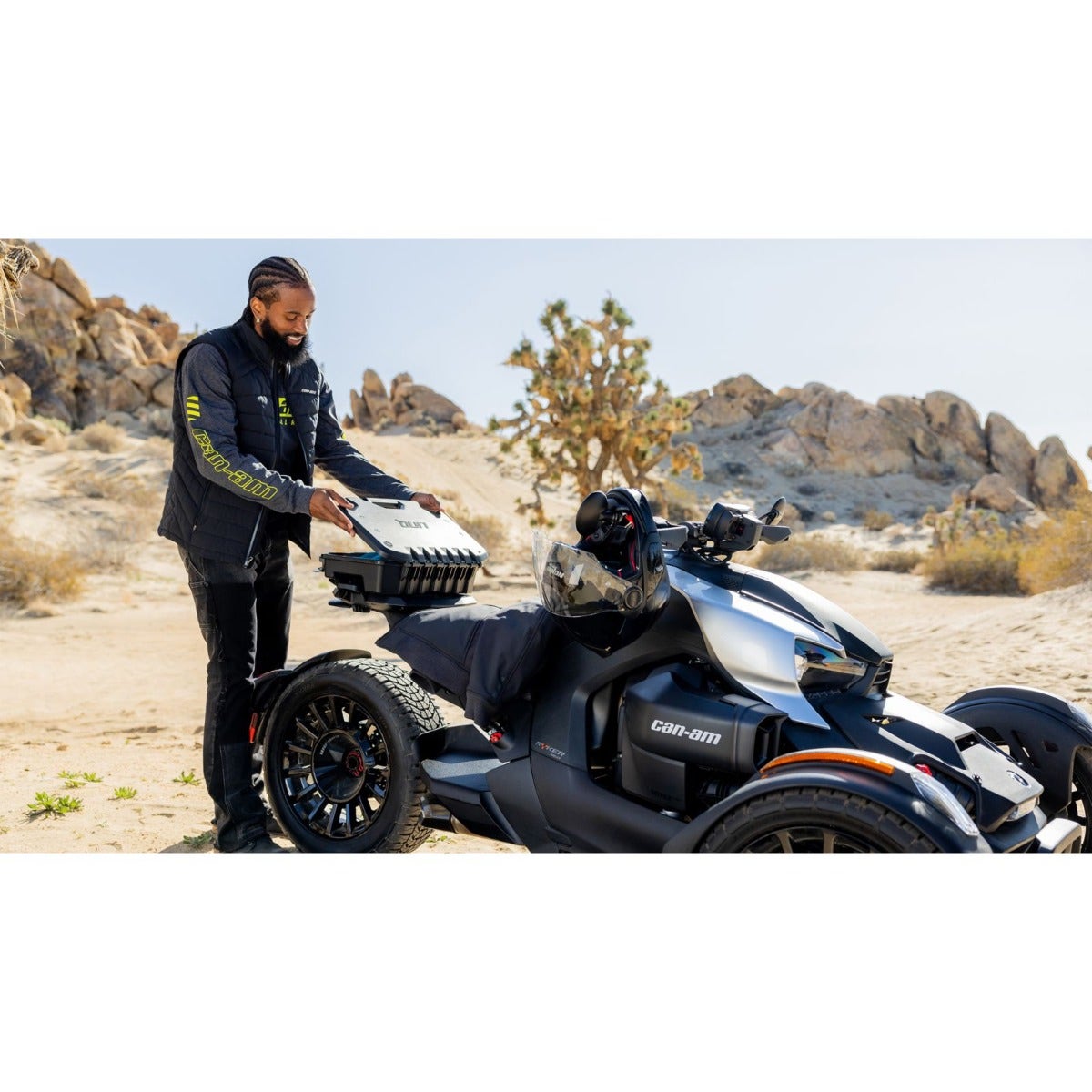 Rider mounting Can-Am LinQ 2.6 gal modular cargo box on Ryker three-wheeler in desert