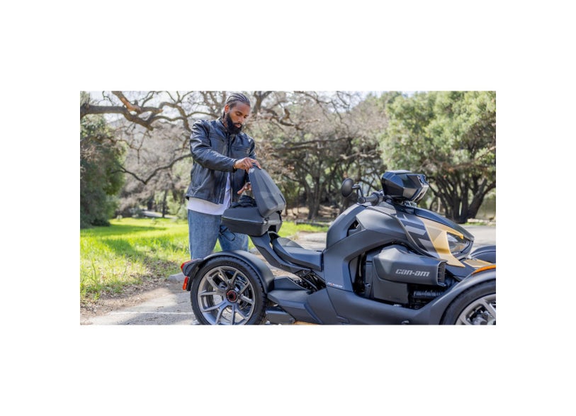 Rider loading Can-Am Ryker LinQ Top Case 16L onto Can-Am Ryker three-wheeler