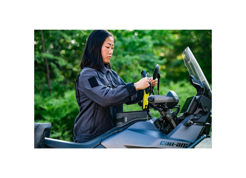 Rider attaching Can-Am Origin LinQ tank bag to EV motorcycle handlebars outdoors