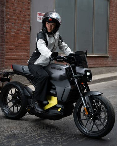 Rider on Can-Am Pulse electric motorcycle with LinQ Sport Windshield installed, front angle view