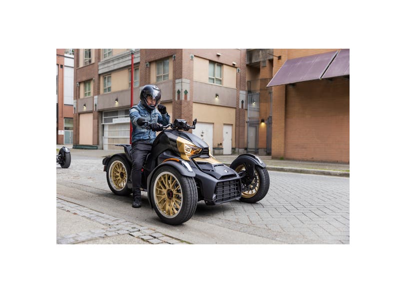 Rider on black Can-Am Ryker three-wheeler with Circuit Liquid Gold wheels parked on city street