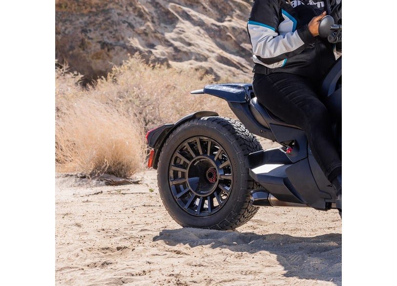 Can-Am Ryker Rally rear wheel deep black on three-wheeler parked in desert sand