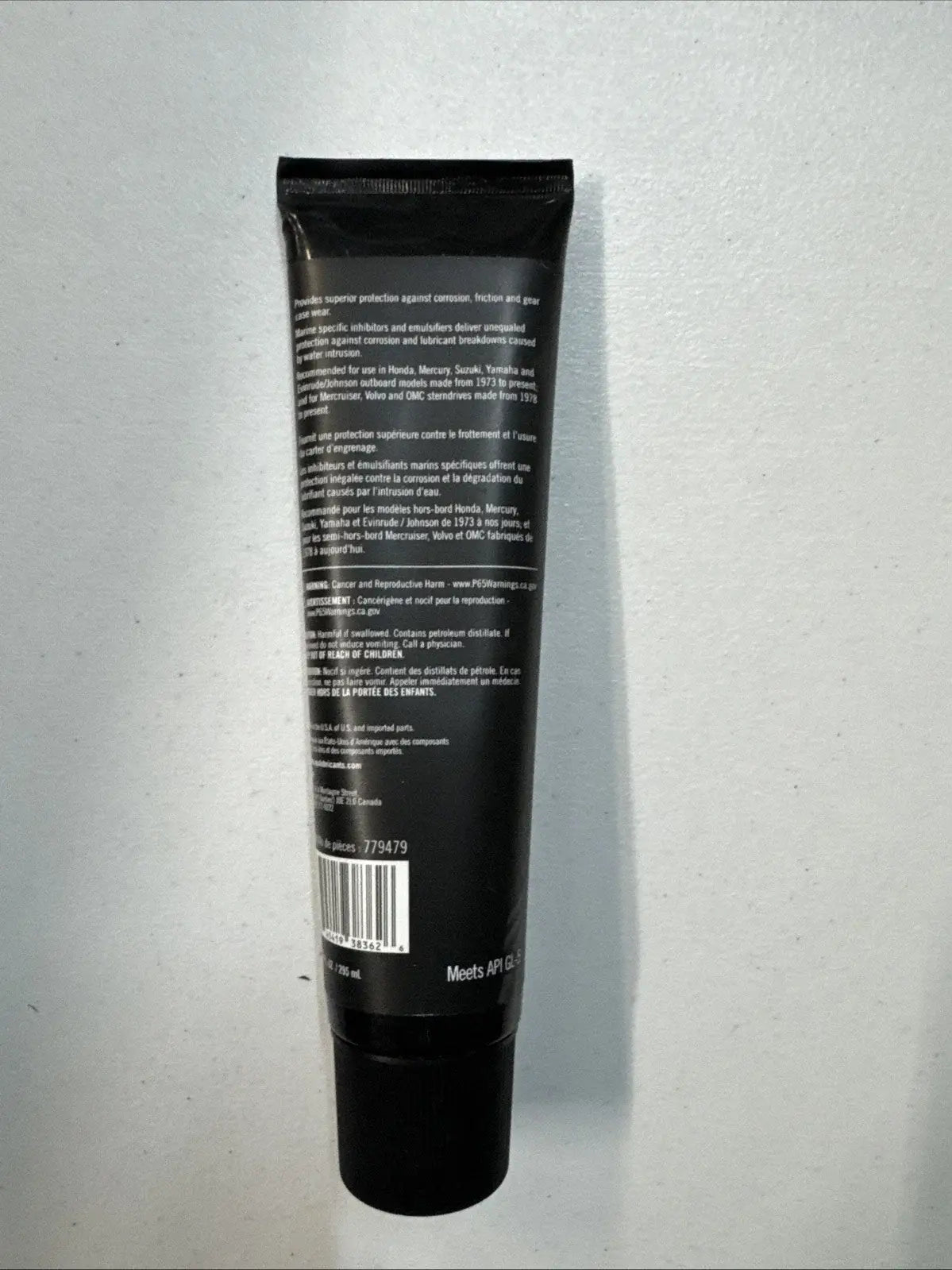 Black tube with text and a barcode on a gray background