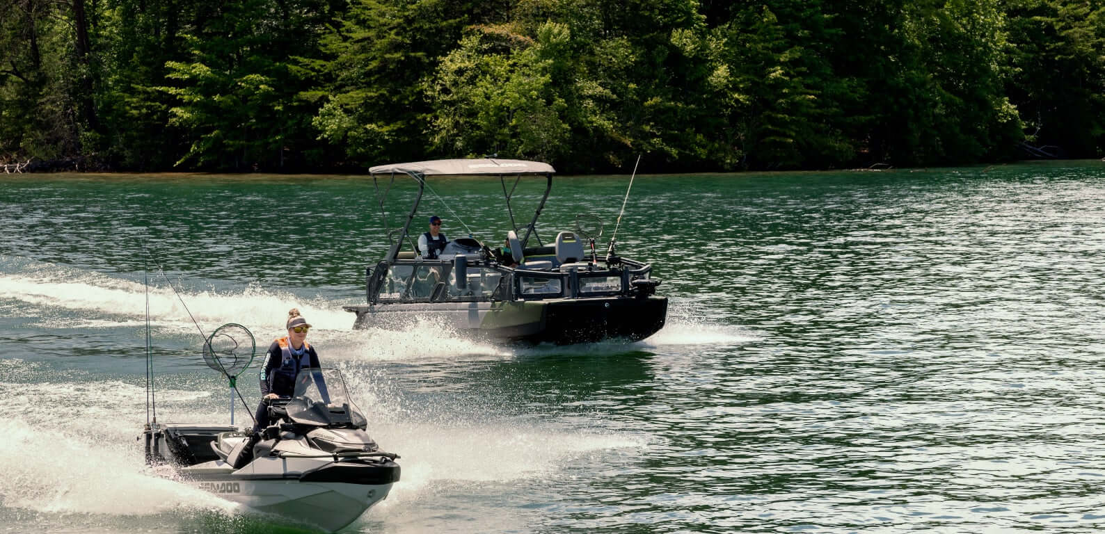Two boats on a lake with a forested shoreline