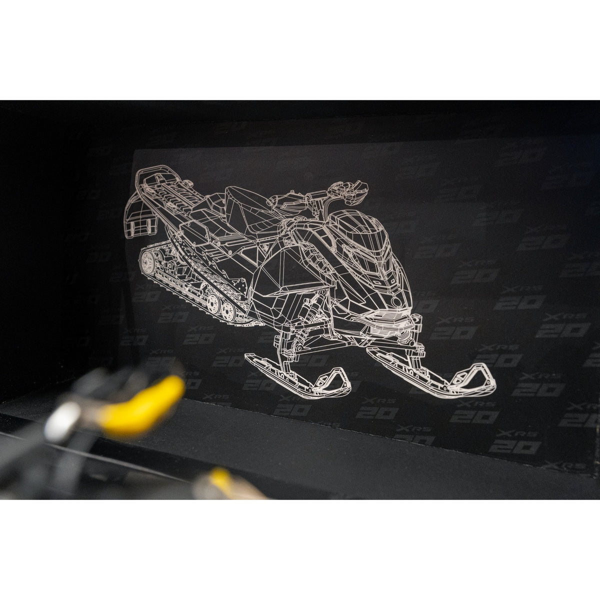 XRS 20 patterned backdrop with snowmobile line art from the anniversary replica box
