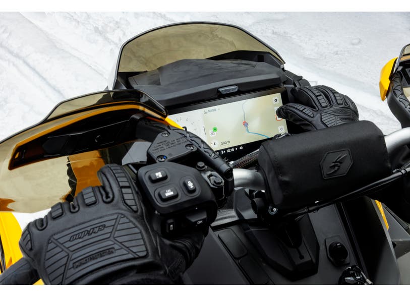 Ski-Doo GPS module with Group Ride feature on snowmobile display, rider gloves on handlebars, 860202990
