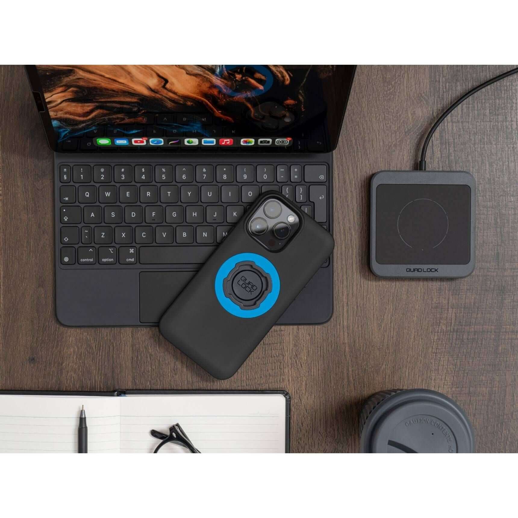 Phone case with blue circle on a desk next to a laptop